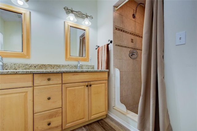 921 24th Ave N, Saint Petersburg, FL 33704 - bathroom with a tile shower, double vanity, and wood finished floors