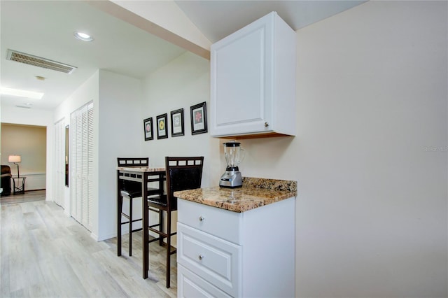 921 24th Ave N, Saint Petersburg, FL 33704 - kitchen featuring light wood-type flooring, light stone countertops, white cabinetry, and recessed lighting