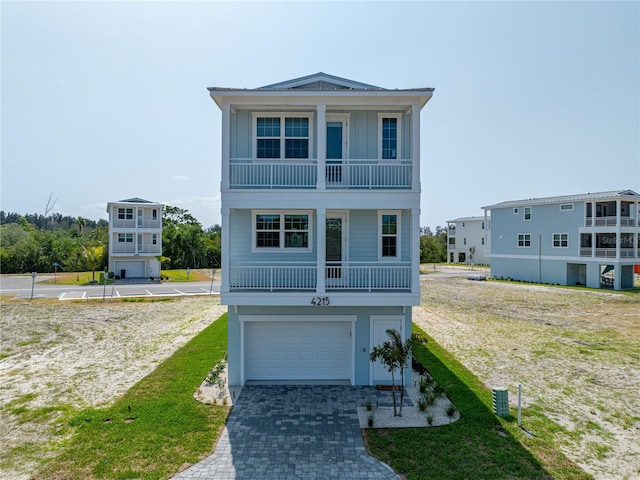 4215 Saltwater Pearl Way, Cortez, FL 34215 - raised beach house with a balcony, a garage, board and batten siding, driveway, and a front lawn
