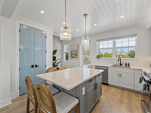 4215 Saltwater Pearl Way, Cortez, FL 34215 - kitchen with appliances with stainless steel finishes, light wood-type flooring, wooden ceiling, a kitchen breakfast bar, and backsplash