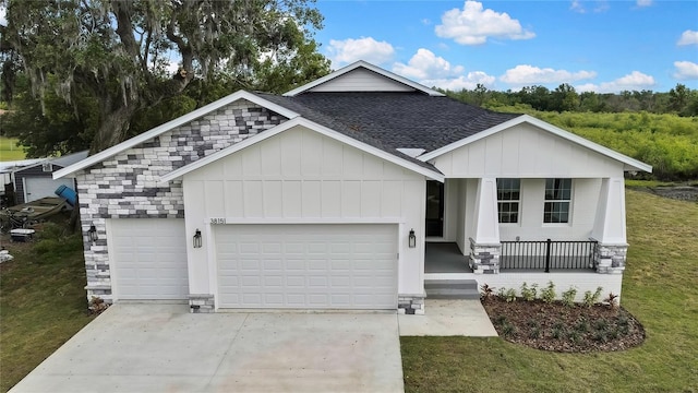 view of front facade with concrete driveway, board and batten siding, covered porch, a garage, and a shingled roof