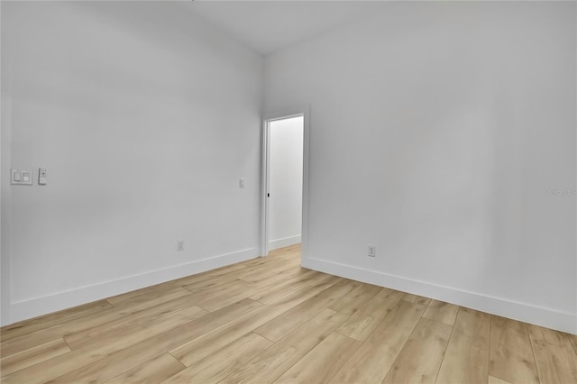 empty room featuring baseboards and light wood-style floors