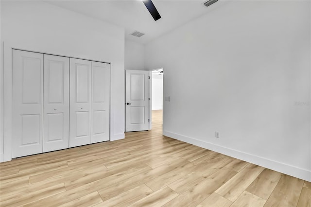 unfurnished bedroom with baseboards, visible vents, a closet, and light wood-type flooring