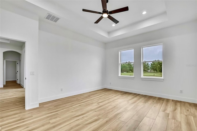 spare room with baseboards, visible vents, light wood-style floors, and a ceiling fan