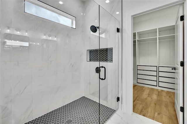 bathroom featuring wood finished floors and a stall shower