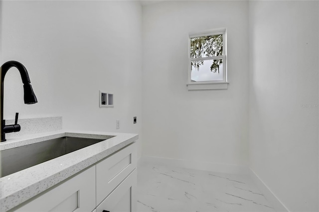 bathroom with marble finish floor, a sink, and baseboards