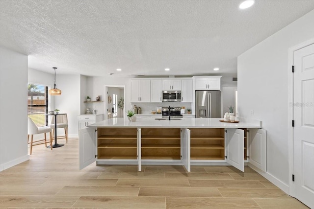 kitchen featuring a sink, light countertops, open shelves, and stainless steel appliances