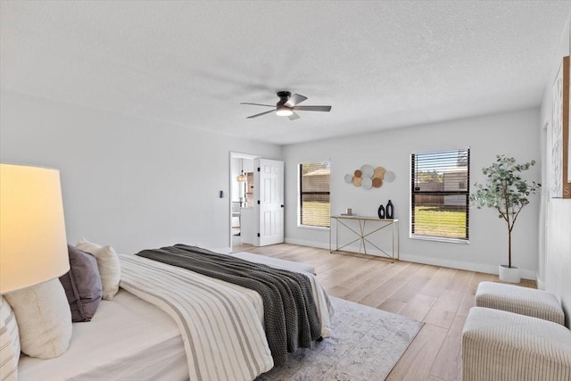 bedroom with baseboards, a ceiling fan, wood finished floors, and a textured ceiling