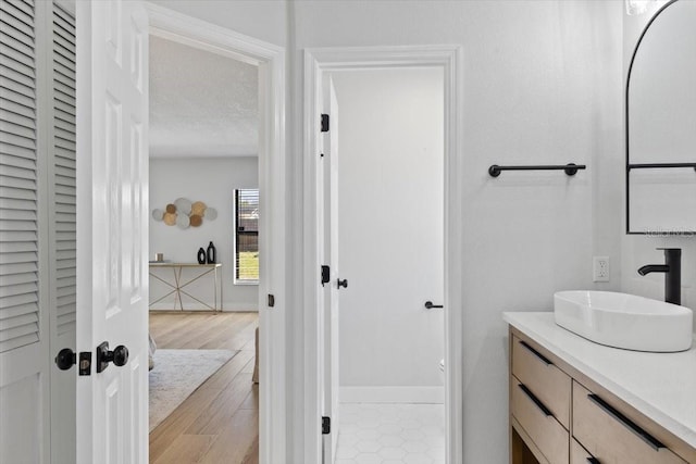 bathroom featuring wood finished floors, vanity, and baseboards