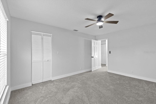 unfurnished bedroom with visible vents, a textured ceiling, baseboards, and carpet floors