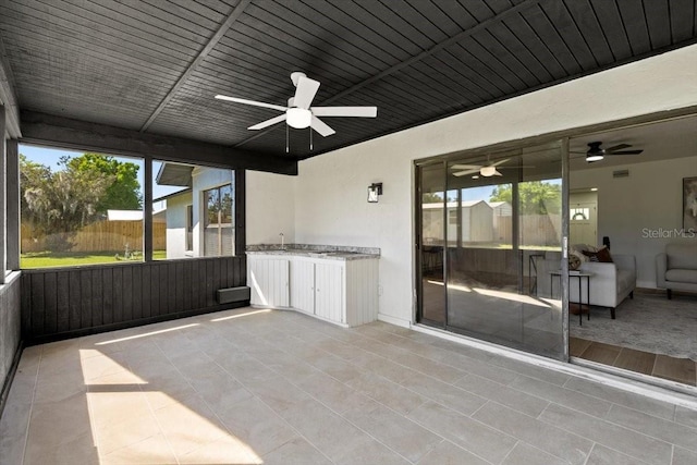 unfurnished sunroom featuring ceiling fan