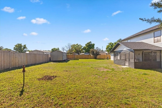 view of yard with a fenced backyard, an outdoor structure, a sunroom, and a shed
