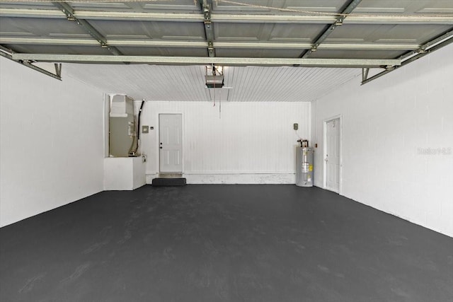 garage with a garage door opener, electric water heater, and heating unit