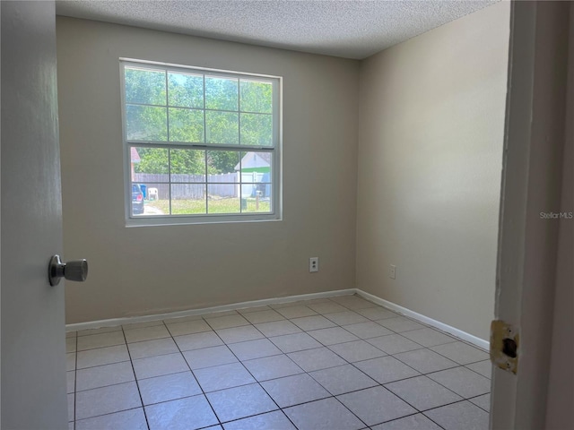 8804 Briar Hollow Ct, Tampa, FL 33634 - empty room featuring baseboards, a textured ceiling, and light tile patterned floors