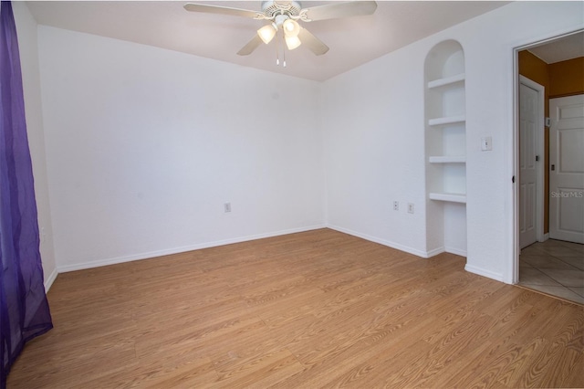 unfurnished bedroom featuring baseboards, light wood-type flooring, and a ceiling fan