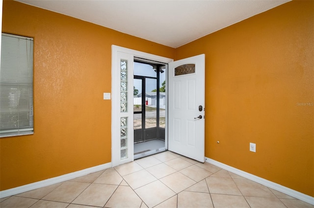 empty room with light tile patterned floors and baseboards