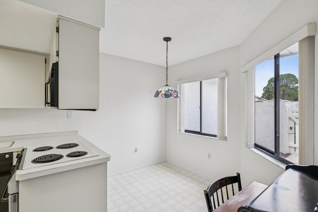 456 Lakeview Dr Unit 5, Palm Harbor, FL 34683 - kitchen featuring white electric range oven, tile patterned floors, light countertops, pendant lighting, and a textured ceiling