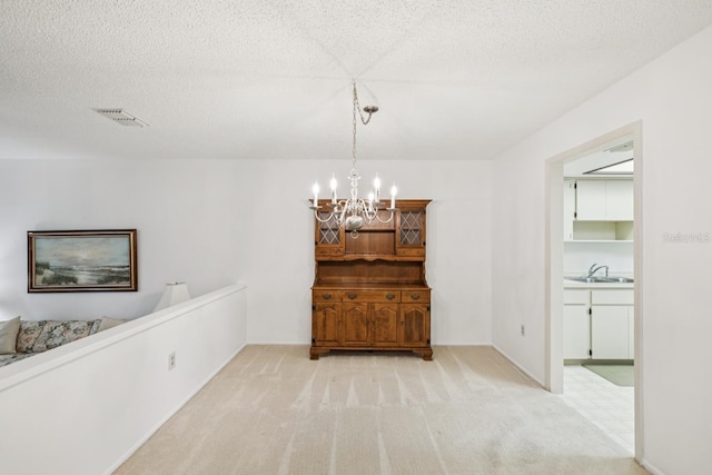 456 Lakeview Dr Unit 5, Palm Harbor, FL 34683 - dining area featuring a chandelier, light colored carpet, and a textured ceiling
