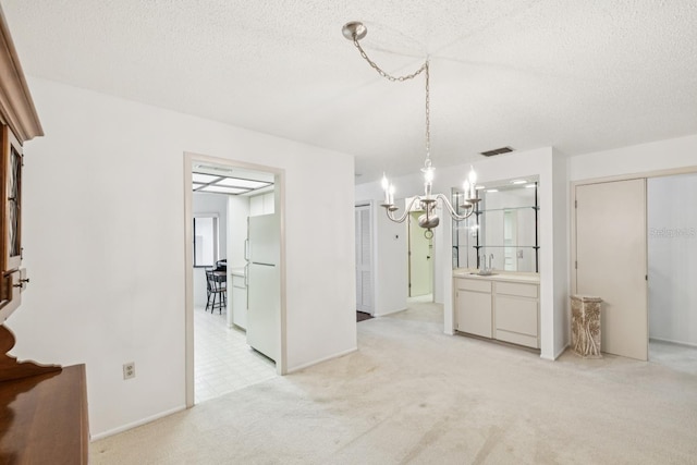 456 Lakeview Dr Unit 5, Palm Harbor, FL 34683 - unfurnished dining area with a chandelier, a sink, a textured ceiling, light carpet, and baseboards