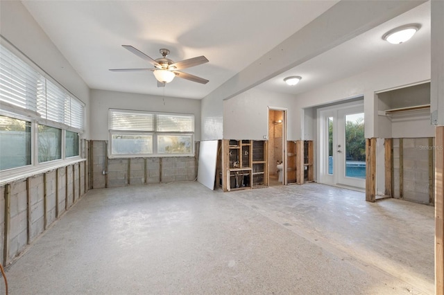 unfurnished living room with concrete floors, ceiling fan, and a healthy amount of sunlight