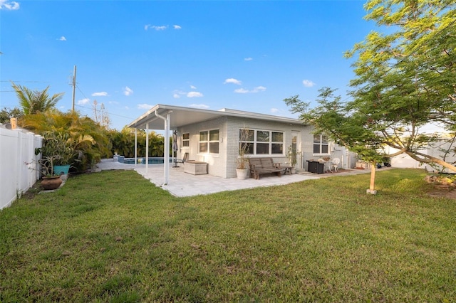 rear view of property featuring a fenced in pool, a patio area, a lawn, and a fenced backyard