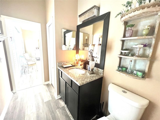 2332 Dekan Ln, Land O Lakes, FL 34639 - bathroom featuring baseboards, wood finished floors, vanity, and toilet