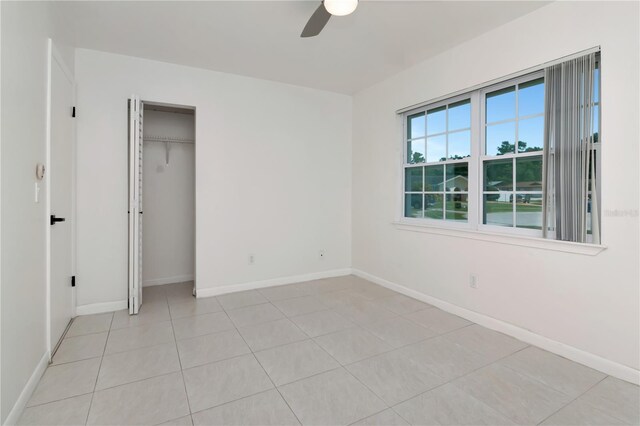 10705 Knollsway Ct, Tampa, FL 33625 - unfurnished bedroom featuring a closet, baseboards, a ceiling fan, and light tile patterned floors