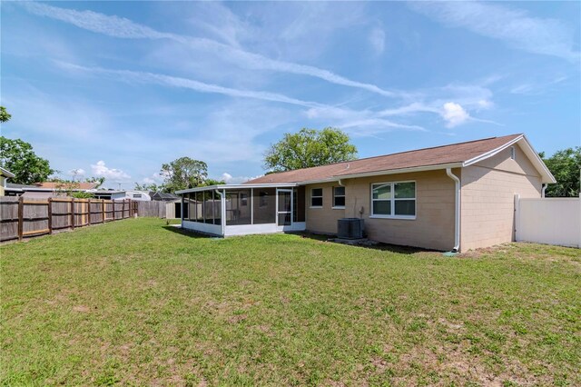 10705 Knollsway Ct, Tampa, FL 33625 - rear view of property featuring a sunroom, a yard, concrete block siding, a fenced backyard, and cooling unit