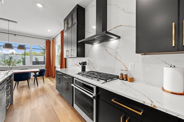 8720 Drummer Plank Dr, Wesley Chapel, FL 33545 - kitchen with appliances with stainless steel finishes, dark cabinetry, wall chimney exhaust hood, light wood-type flooring, and backsplash