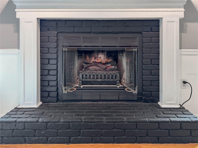 detailed view of a fireplace and a wainscoted wall