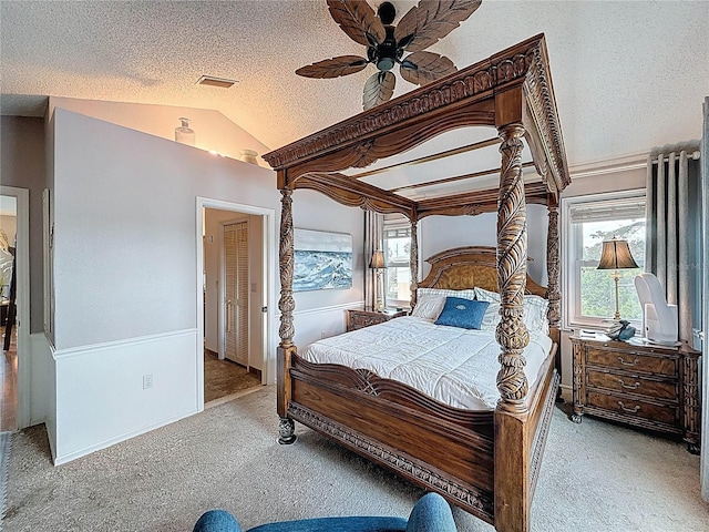 bedroom featuring carpet, lofted ceiling, a textured ceiling, and ceiling fan
