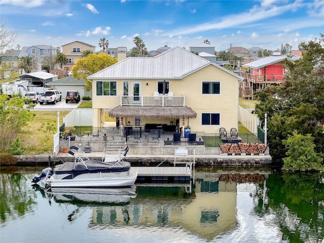 back of house with a fenced backyard, a patio, stucco siding, and a water view