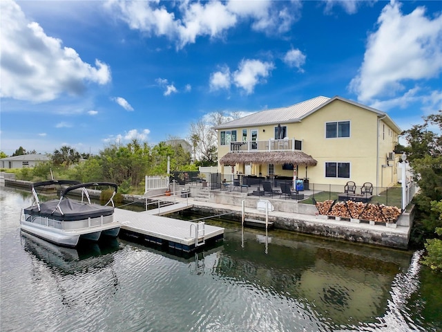 dock featuring a water view, a fire pit, a patio area, and fence