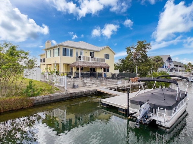 dock area featuring a water view, a fenced backyard, and a patio area