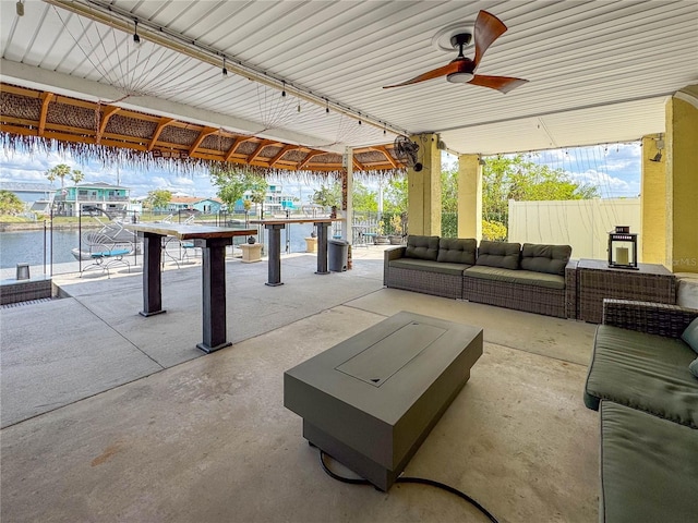 view of patio / terrace with an outdoor hangout area, a water view, ceiling fan, and fence
