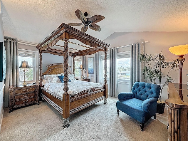 bedroom with light colored carpet, multiple windows, a textured ceiling, and vaulted ceiling