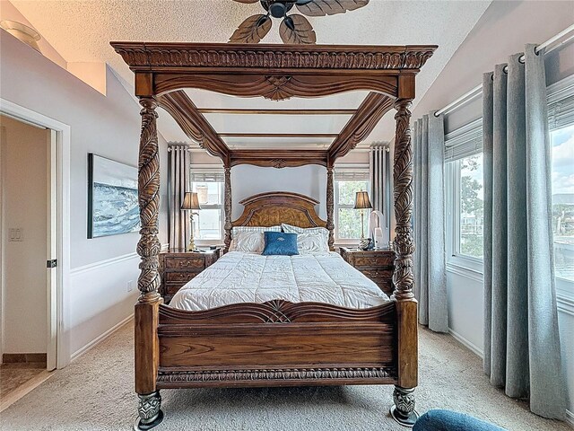 bedroom with light colored carpet, baseboards, a textured ceiling, and ceiling fan