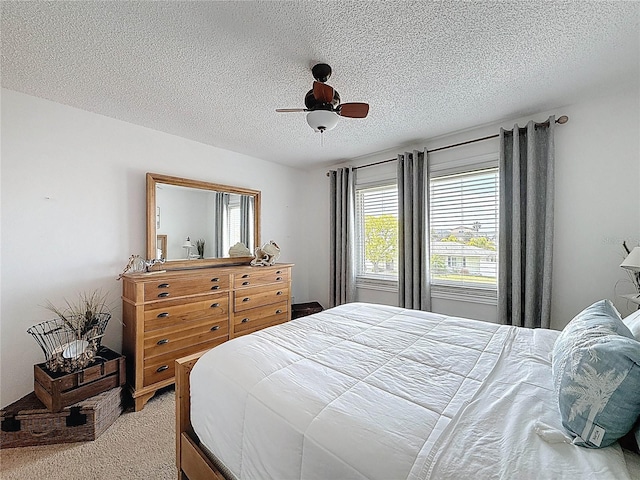 bedroom with light colored carpet, a textured ceiling, and ceiling fan