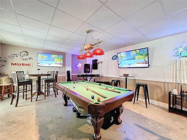rec room featuring concrete flooring, a paneled ceiling, pool table, and wainscoting
