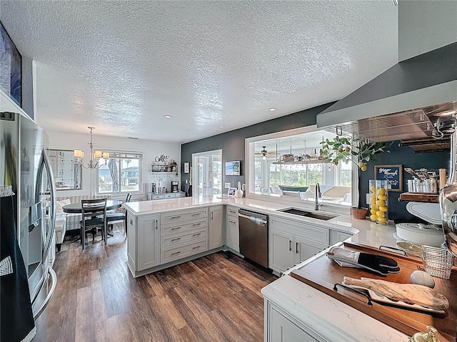 4116 Diaz Ct, Hernando Beach, FL 34607 - kitchen featuring stainless steel appliances, a sink, a chandelier, a textured ceiling, and range hood