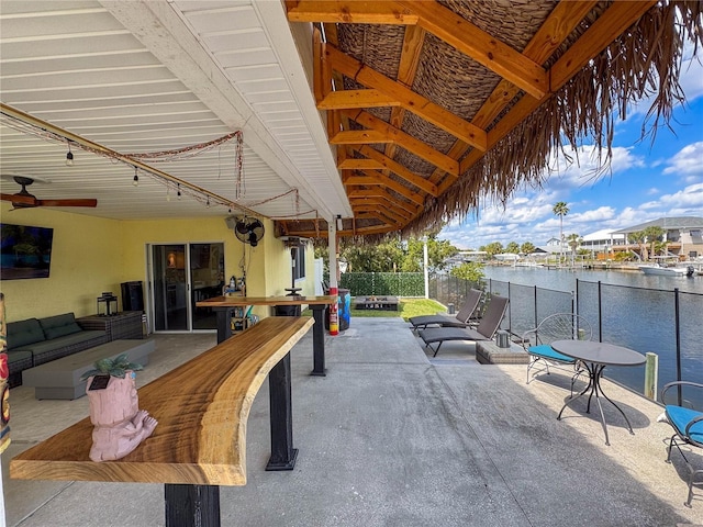 4116 Diaz Ct, Hernando Beach, FL 34607 - view of patio featuring a water view, an outdoor living space with a fire pit, fence, and a ceiling fan
