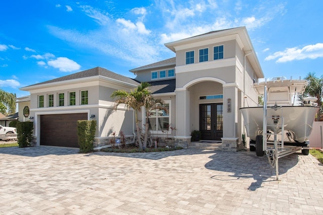 182 E Canal Dr, Palm Harbor, FL 34684 - view of front facade with stucco siding, french doors, decorative driveway, a garage, and a shingled roof