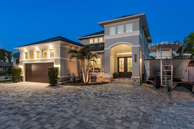 182 E Canal Dr, Palm Harbor, FL 34684 - view of front of property with french doors, a garage, stucco siding, and decorative driveway