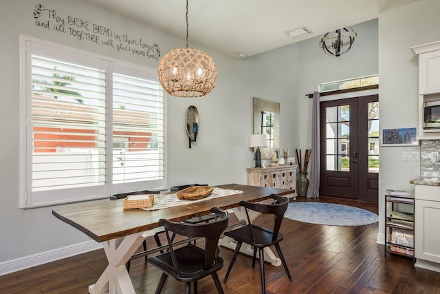 182 E Canal Dr, Palm Harbor, FL 34684 - dining space featuring a healthy amount of sunlight, a notable chandelier, baseboards, and dark wood-style floors