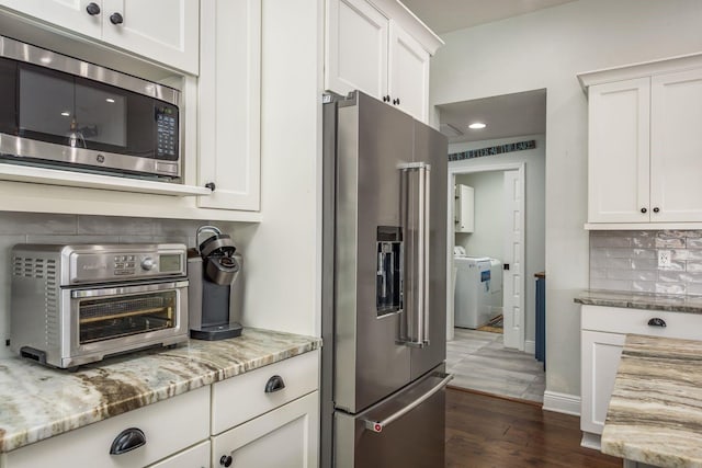 182 E Canal Dr, Palm Harbor, FL 34684 - kitchen with tasteful backsplash, white cabinetry, stainless steel appliances, washer / dryer, and a toaster