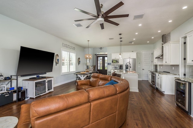 182 E Canal Dr, Palm Harbor, FL 34684 - living room with dark wood-type flooring, visible vents, a ceiling fan, and beverage cooler