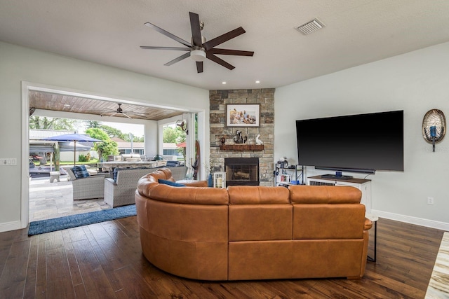 182 E Canal Dr, Palm Harbor, FL 34684 - living area with visible vents, baseboards, dark wood-style flooring, ceiling fan, and a stone fireplace