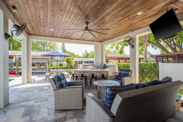 182 E Canal Dr, Palm Harbor, FL 34684 - view of patio with outdoor dry bar, ceiling fan, fence, and an outdoor kitchen
