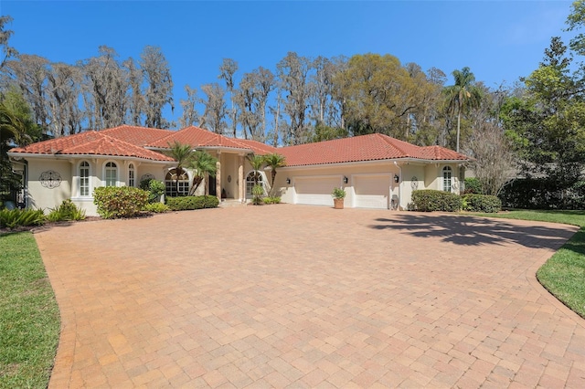 3607 Berger Rd, Lutz, FL 33548 - mediterranean / spanish home featuring a garage, stucco siding, a tile roof, and decorative driveway