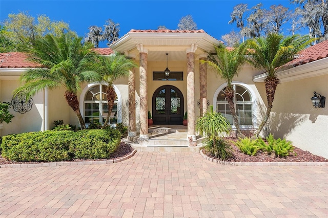 3607 Berger Rd, Lutz, FL 33548 - view of exterior entry featuring french doors, stucco siding, and a tiled roof